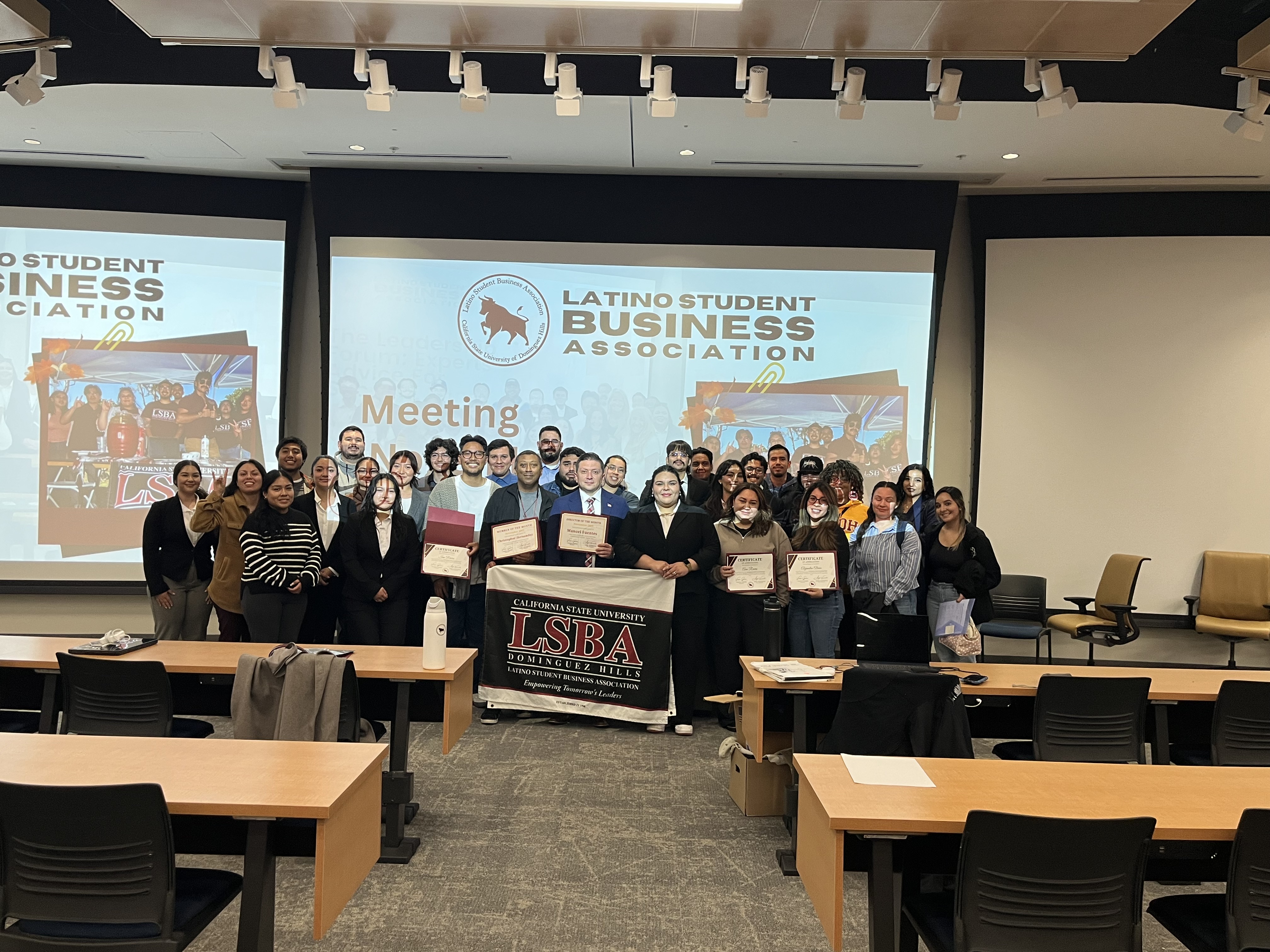 Large group of LSBA members holding certificates and the LSBA Dominguez Hills banner at a chapter meeting.