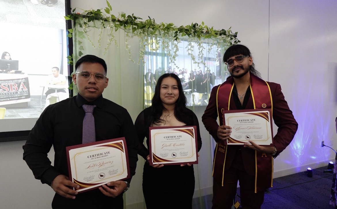 Three LSBA scholarship recipients holding certificates of scholarship on stage at the LSBA Banquet.